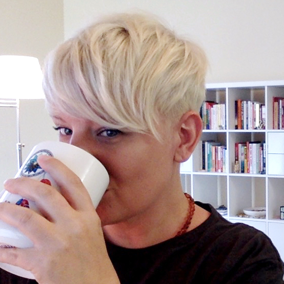 Shannon hides behind her coffee mug.